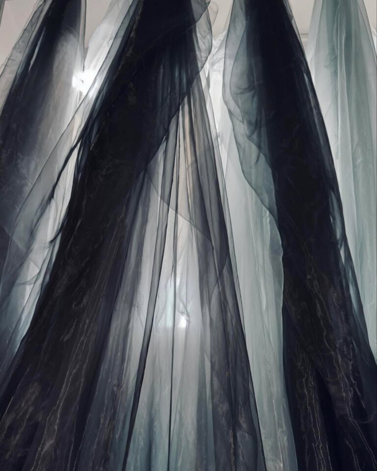 Many layers of fine black and grey tulle falling in soft vertical folds